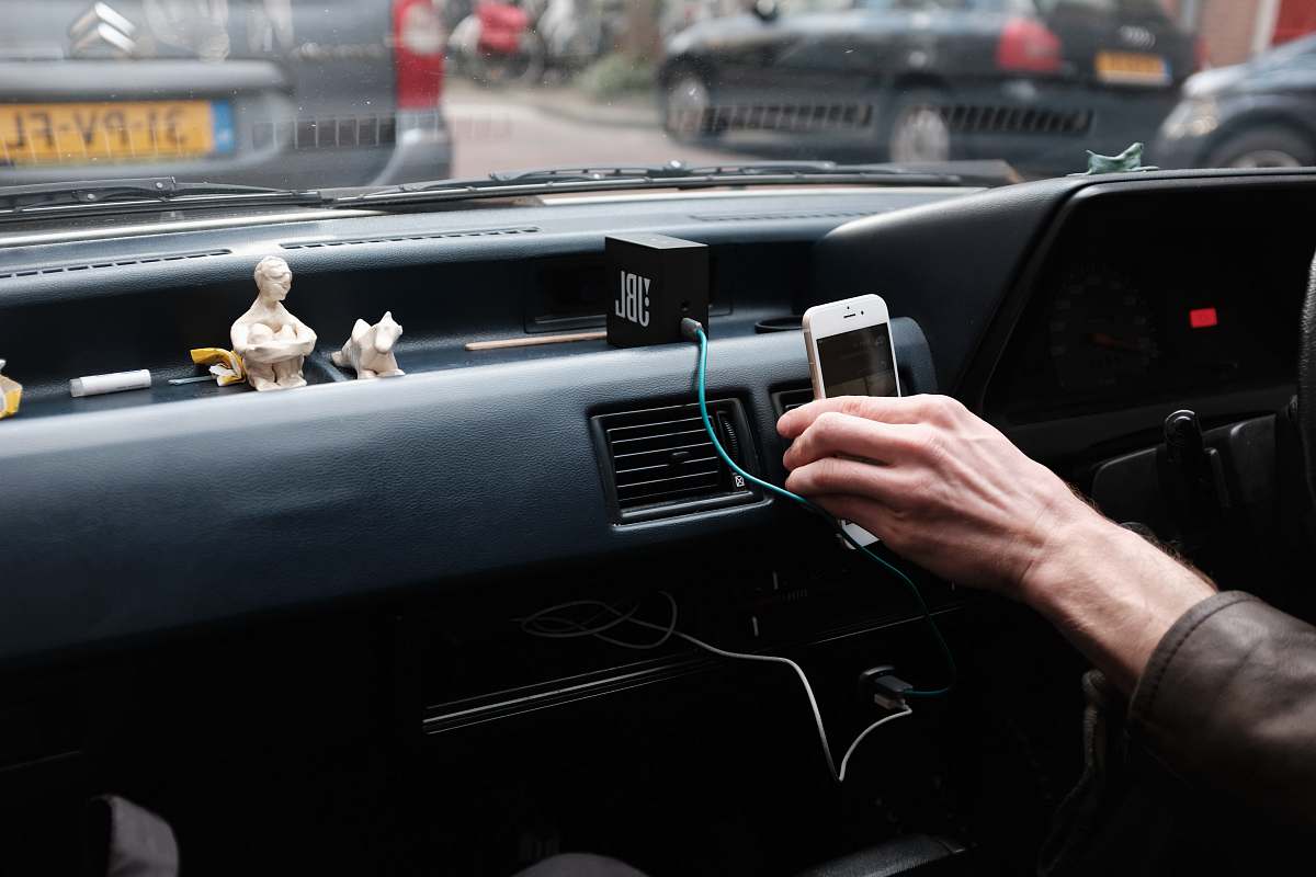 automobile person hand holding iPhone 6 on dashboard during daytime vehicle