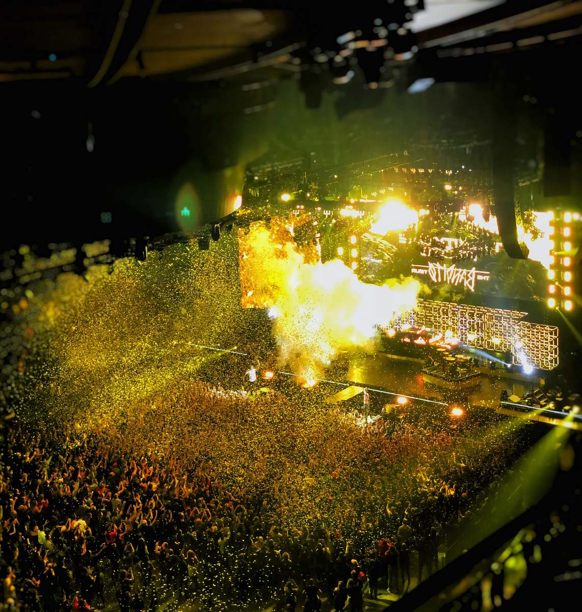light band playing on stage front of crowd during nighttime flare