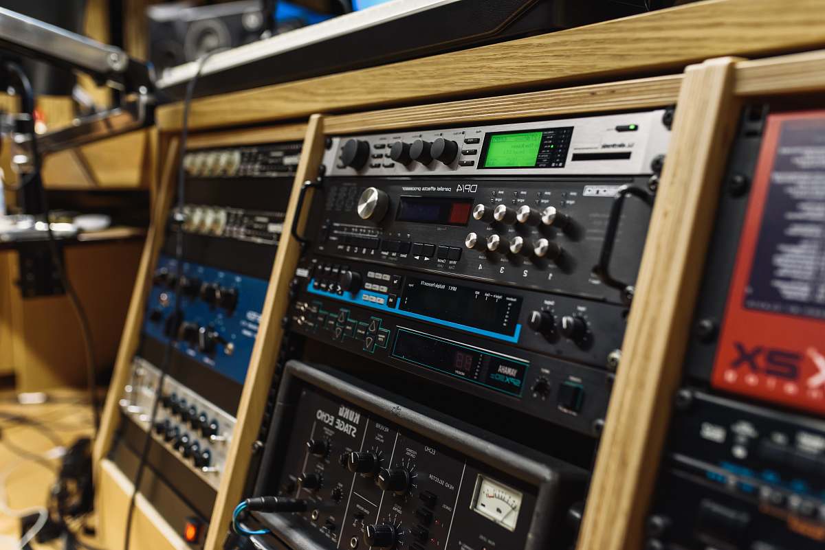 stereo black audio mixer in brown wooden shelf recording