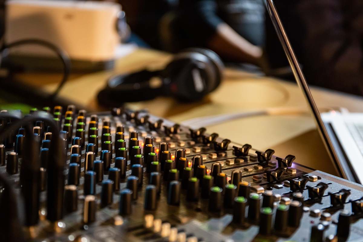 computer person near headphones and mixer keyboard