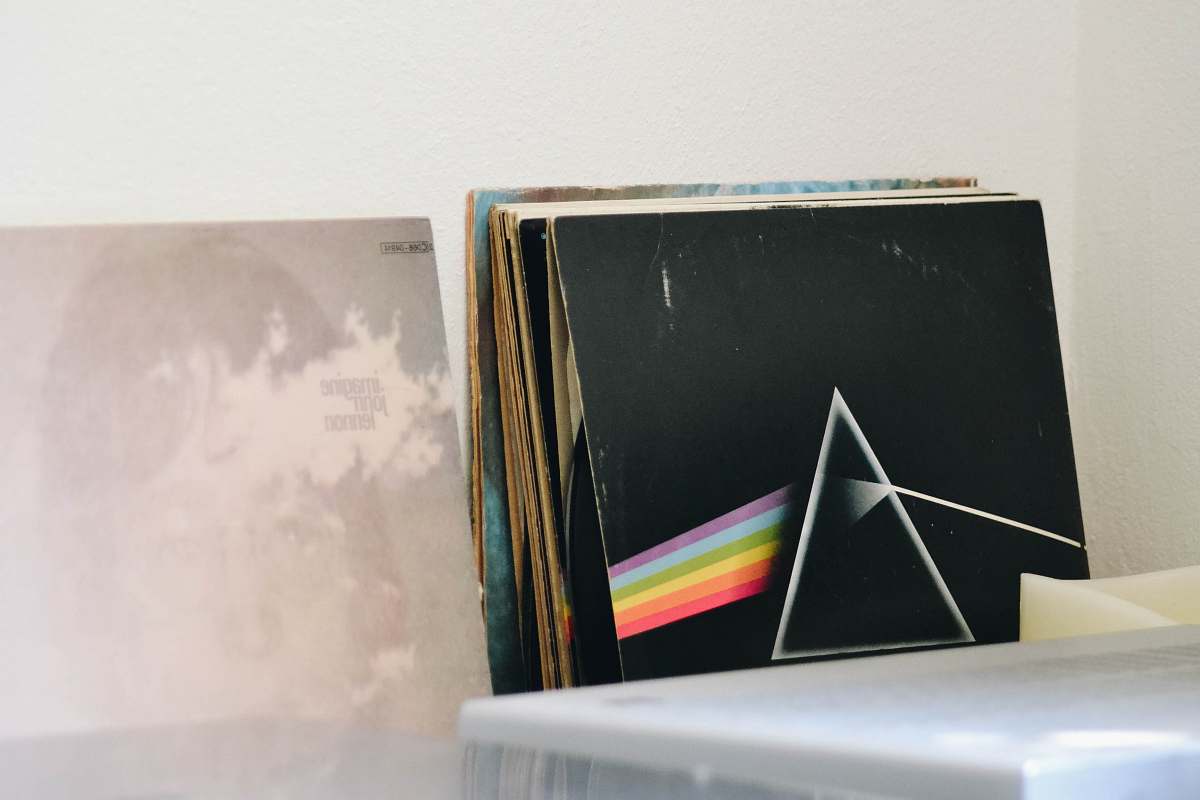 This captivating scene features a modern desk adorned with a sleek laptop and a classic Pink Floyd vinyl album, set against a pristine white wall. Perfect for music enthusiasts, bloggers, and lifestyle brands, this image captures the essence of creative workspace aesthetics and the charm of Parisian culture. Ideal for use in articles about music, interior design, or personal productivity.