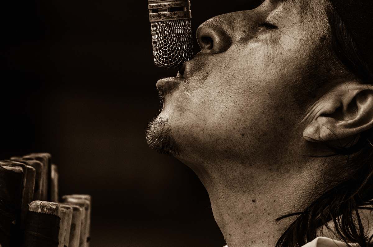 sing man singing with microphone grayscale photography singer