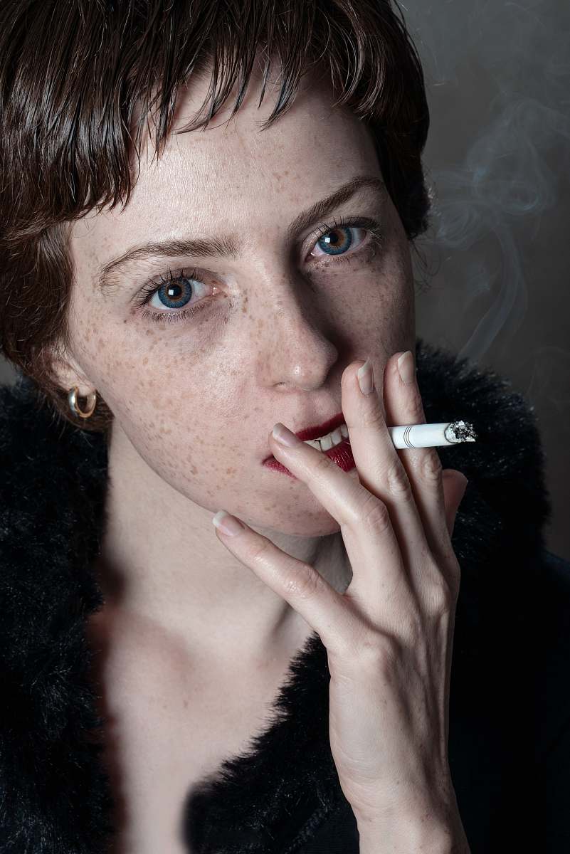 human woman wearing black fur coat smoking person