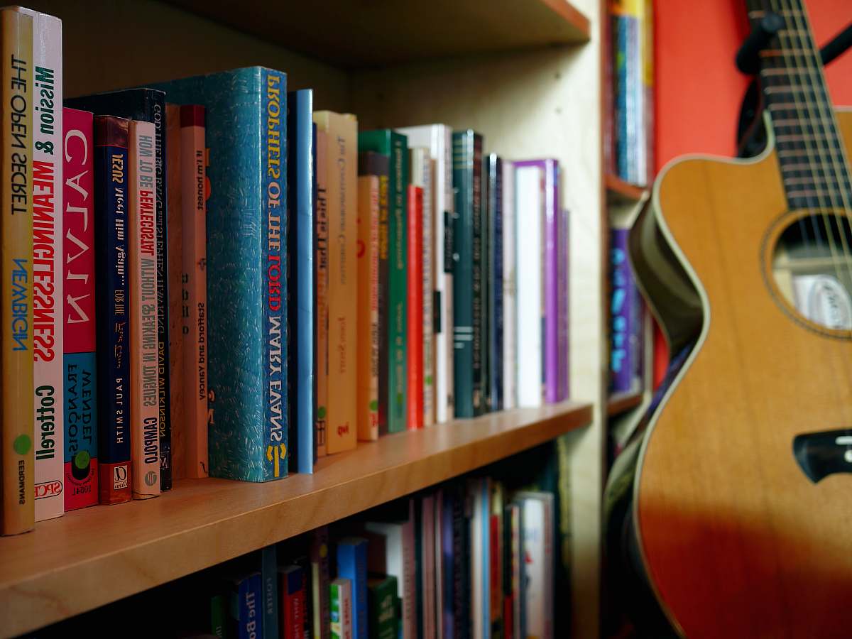 bookcase brown guitar near book shelves close-up photography shelf