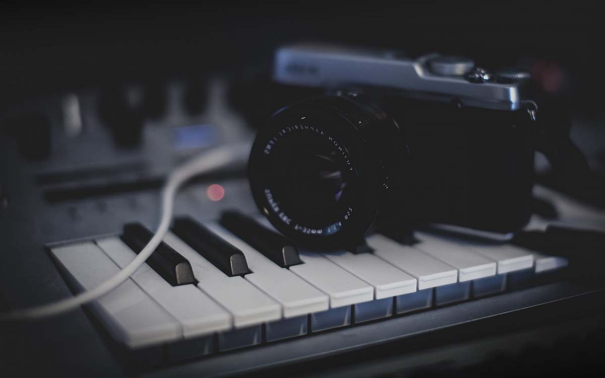 electronics black and gray SLR camera on keyboard camera