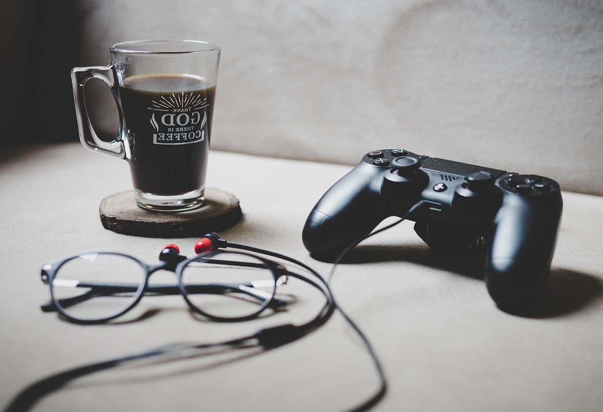drink black Sony Dualshock 4 beside clear glass mug filled with coffee istanbul