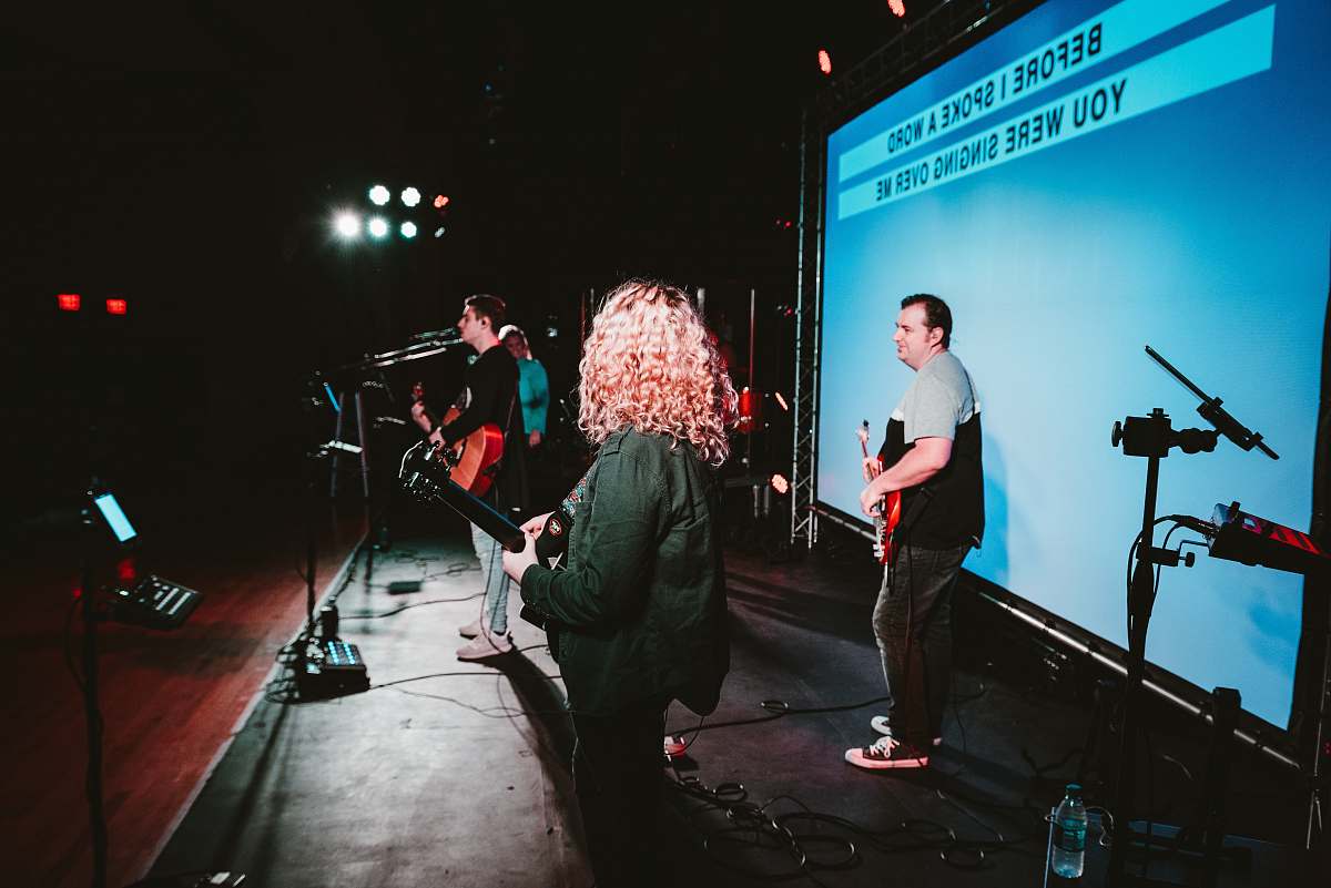 performer four person standing on stage musician