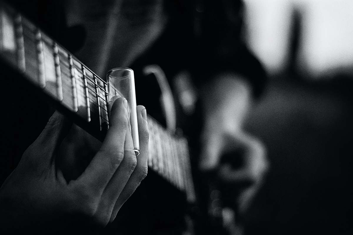 black-and-white grayscale photography of person playing guitar music