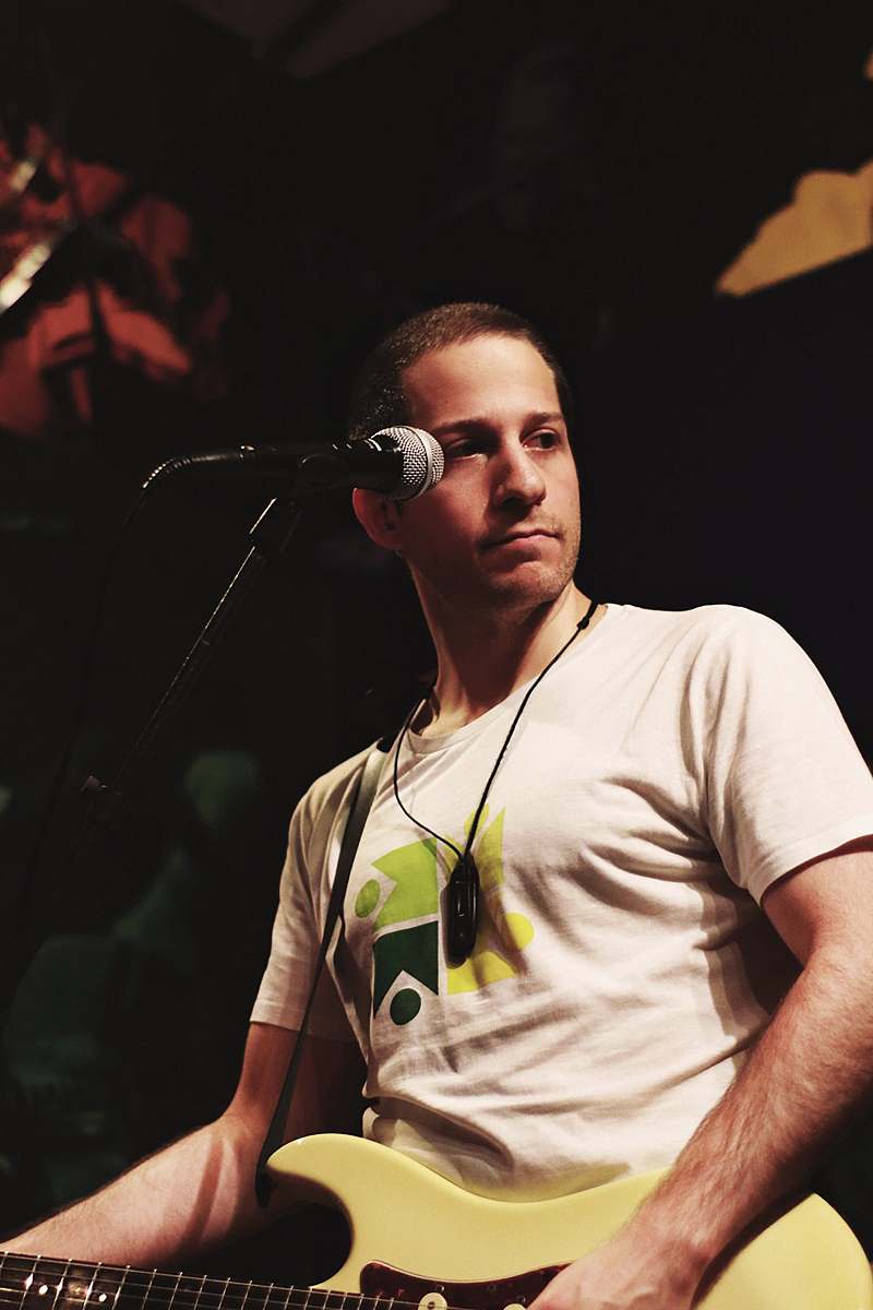 human man wearing white shirt playing guitar person