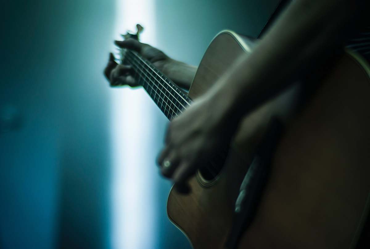 music person playing acoustic guitar shallow focus photography musical instrument