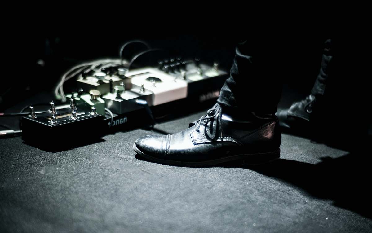 shoe person's feet standing near effects pedals pedal