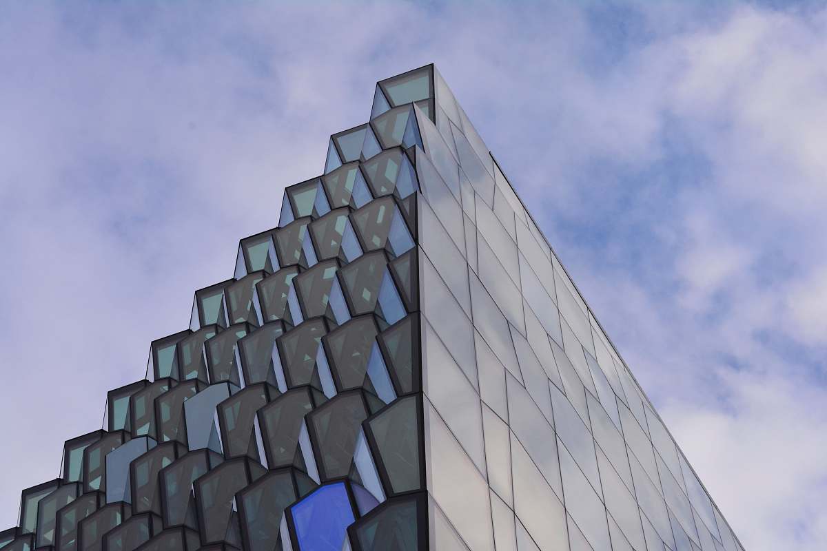 iceland low angle photography of glass building under cloudy sky at daytime building