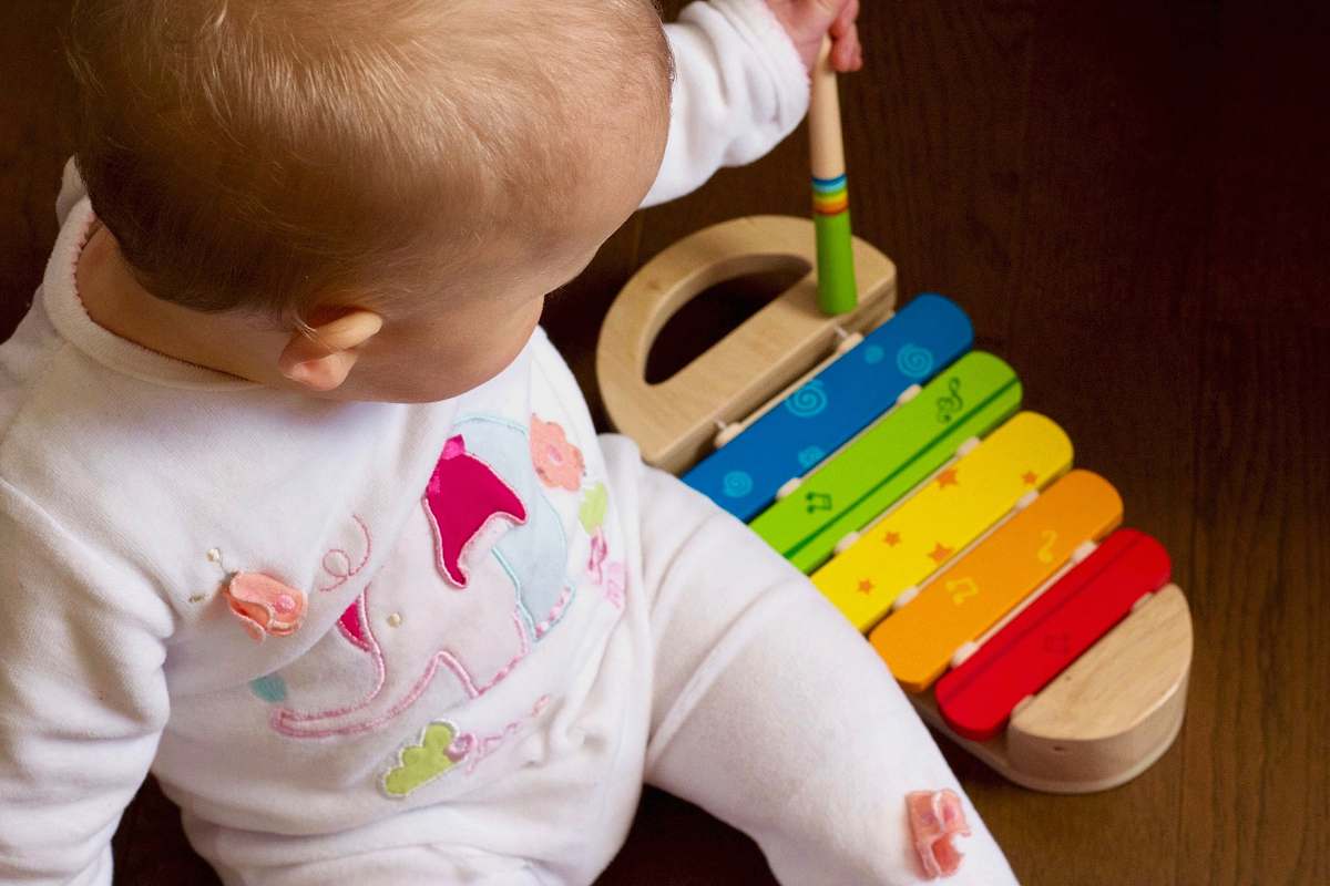 people baby playing multicolored xylophone toy person