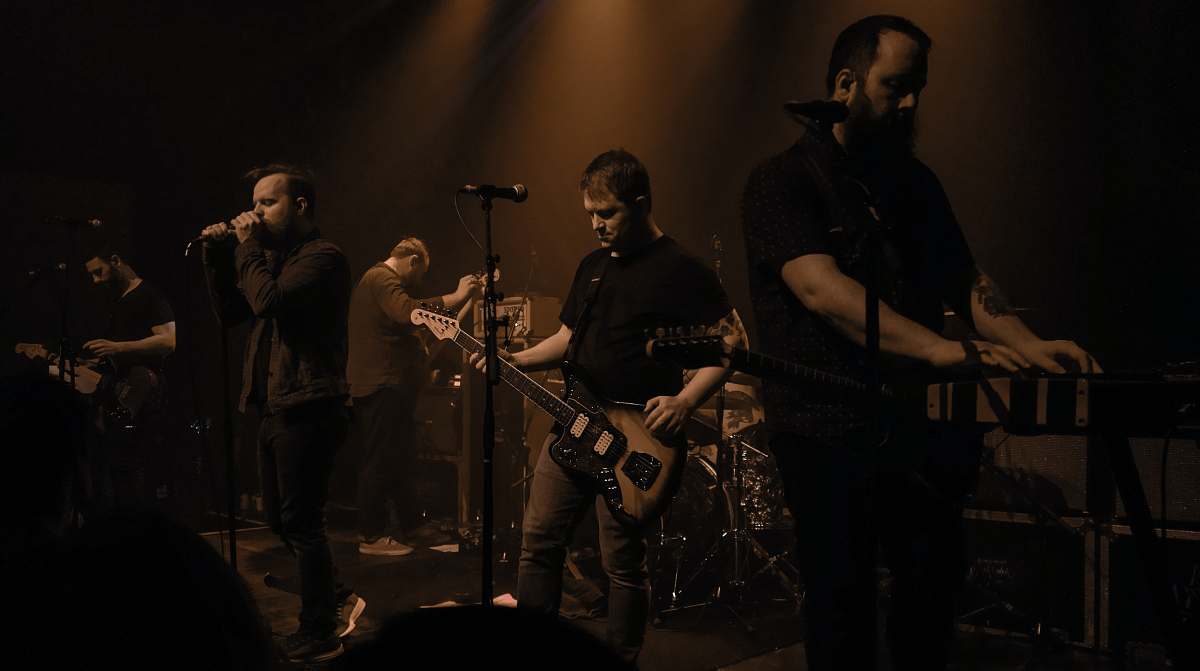 person band group performing on stage guitar