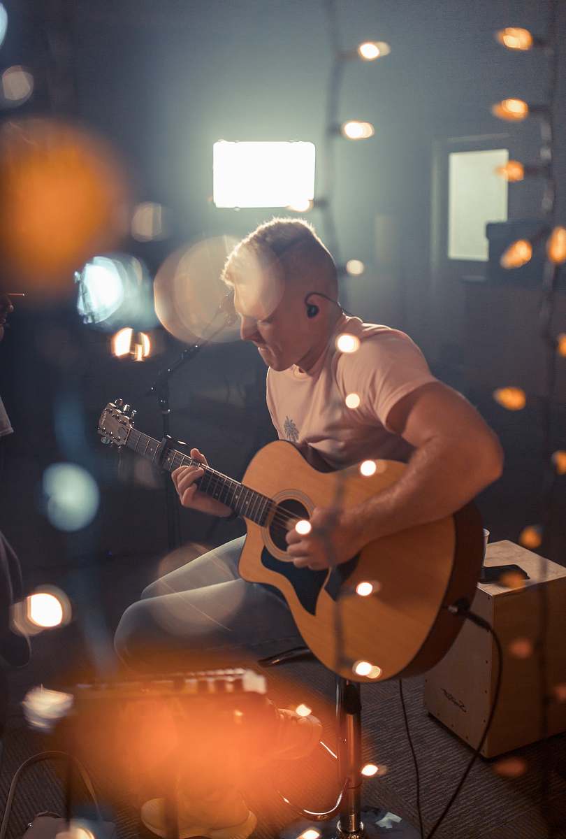 person bokeh photography of man playing guitar people