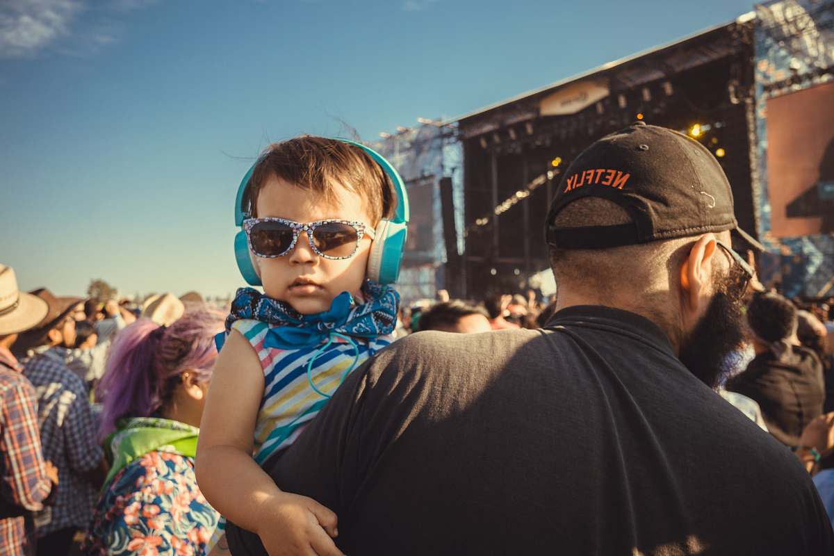 person boy carrying a girl wearing sunglasses and headphones apparel