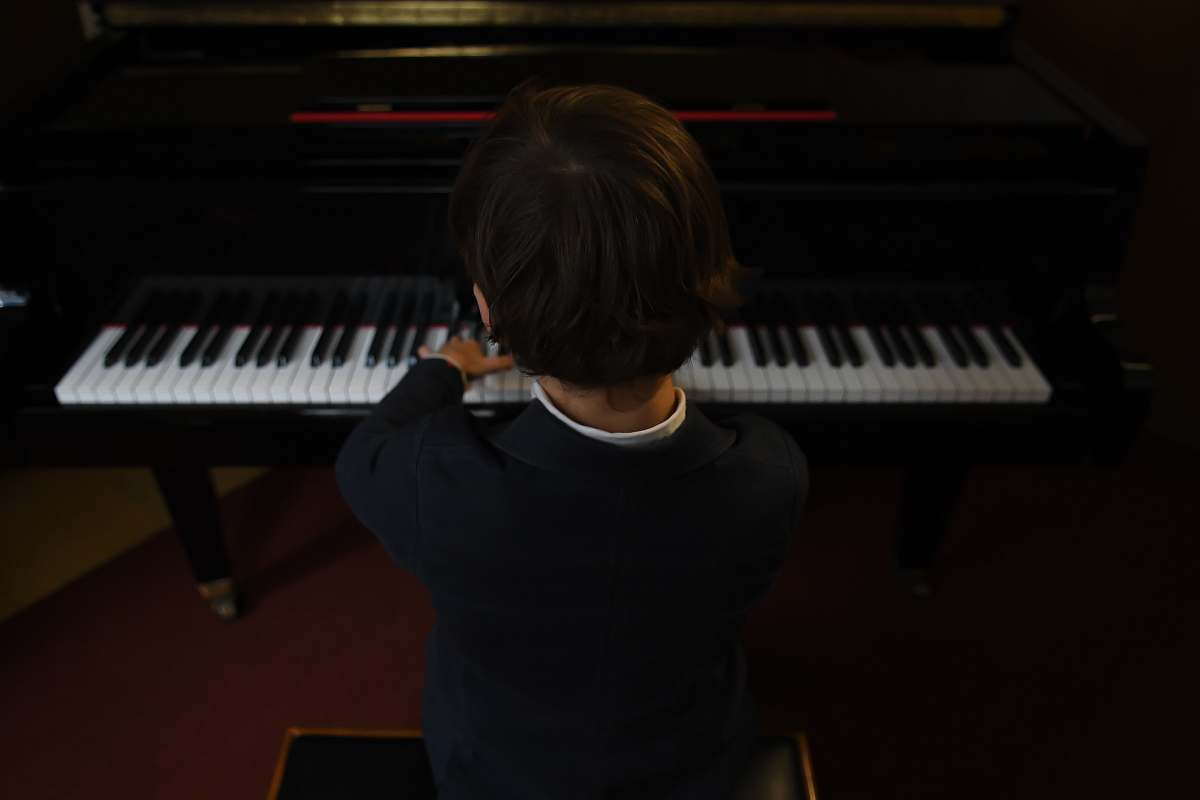 person boy playing a piano performer
