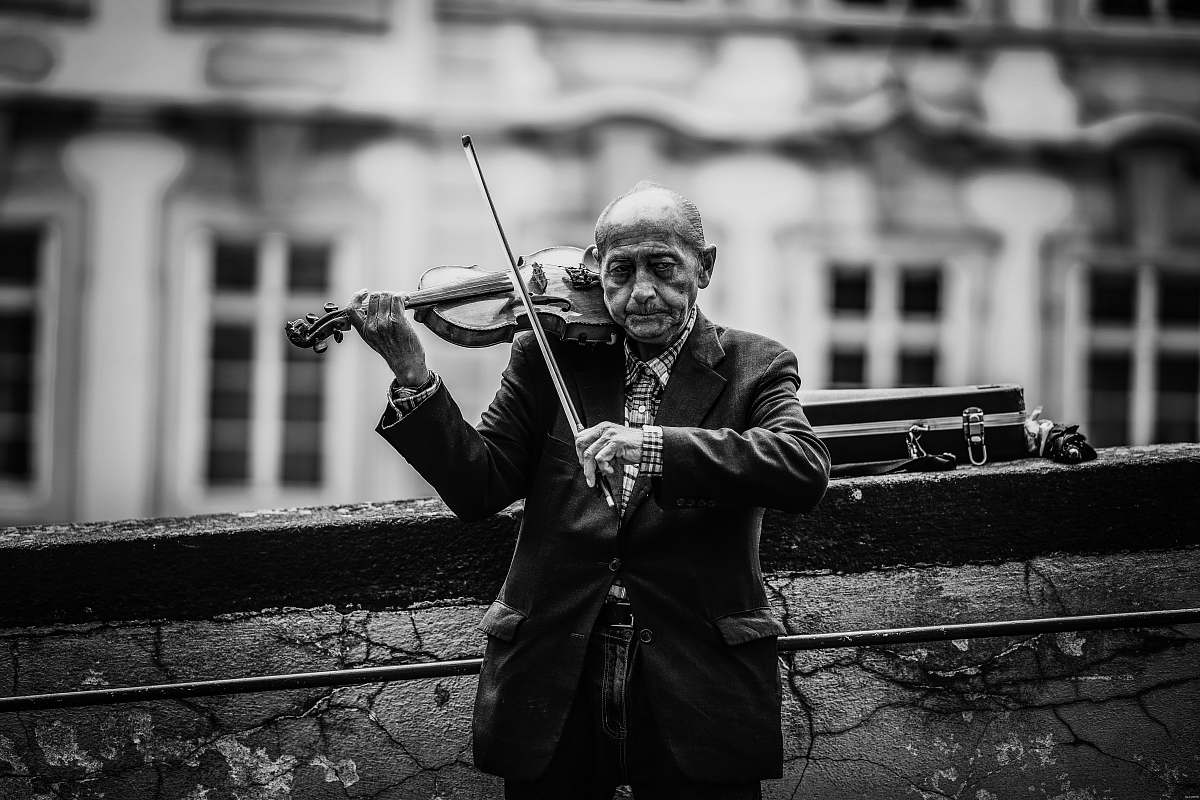 person grayscale photo of a man playing vioin black-and-white