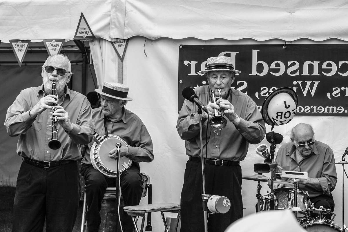 people grayscale photo of group of people playing on stage black-and-white