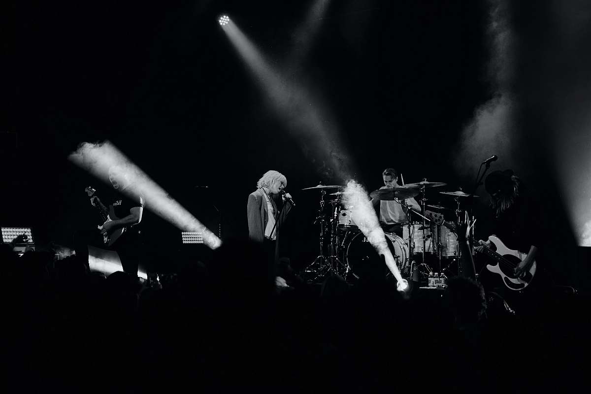 black-and-white grayscale photo of man singing on stage stage
