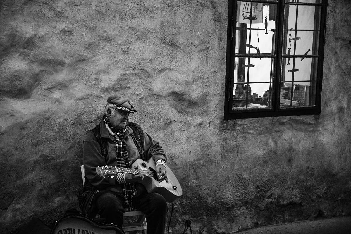 person grayscale photography of man playing guitar black-and-white
