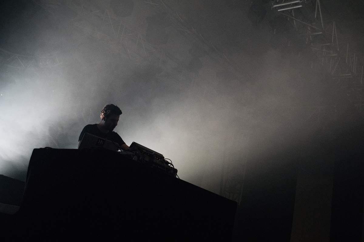 person grayscale photography of man standing and playing audio mixer grey
