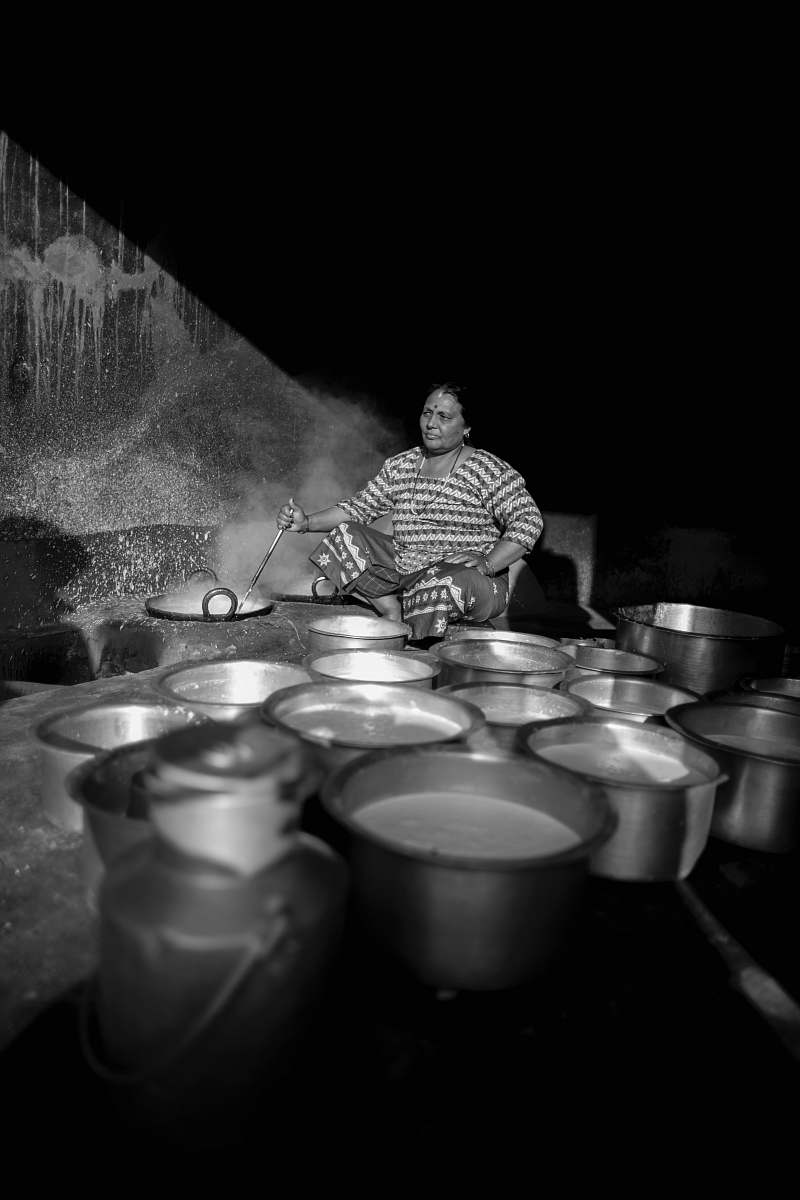 person grayscale photography of woman cooking while holding a ladle black-and-white