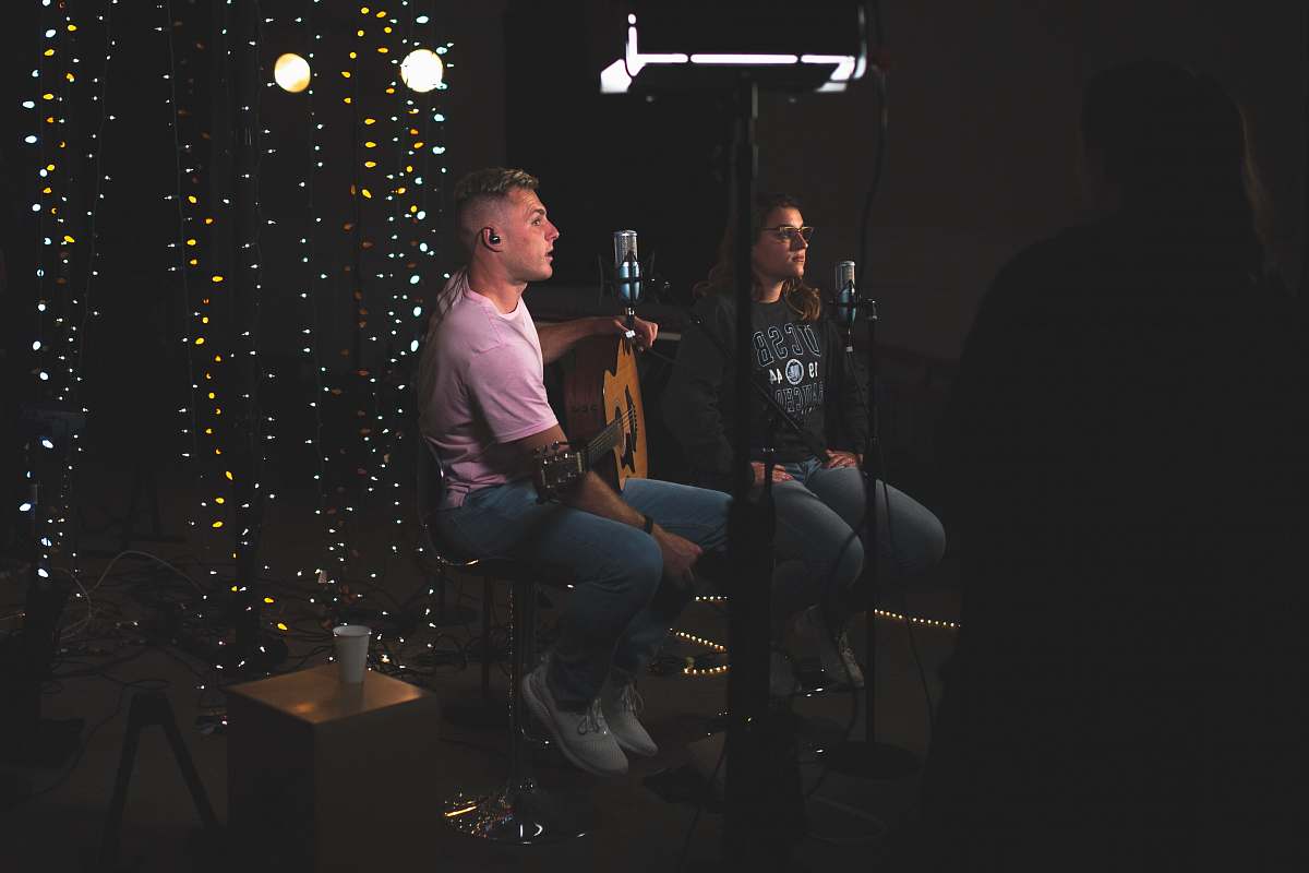 people man and woman sitting side by side in front of microphones person