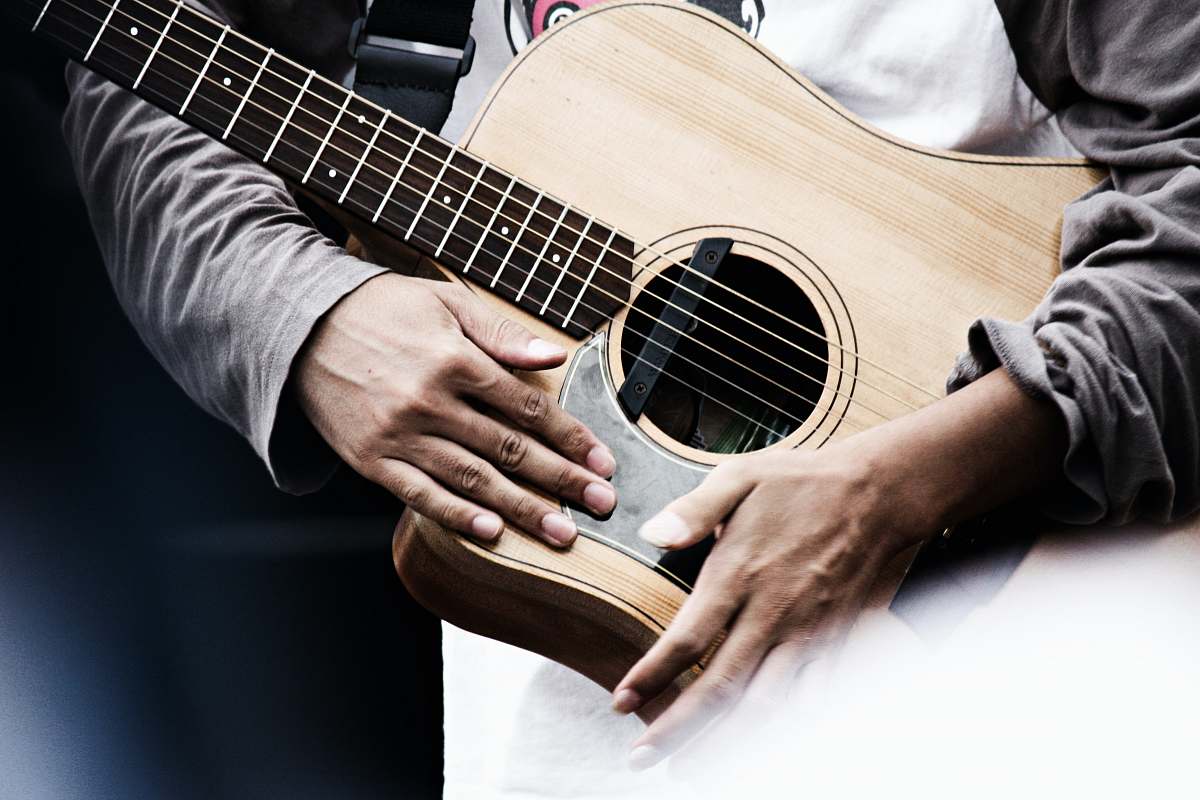 person man holding acoustic guitar people