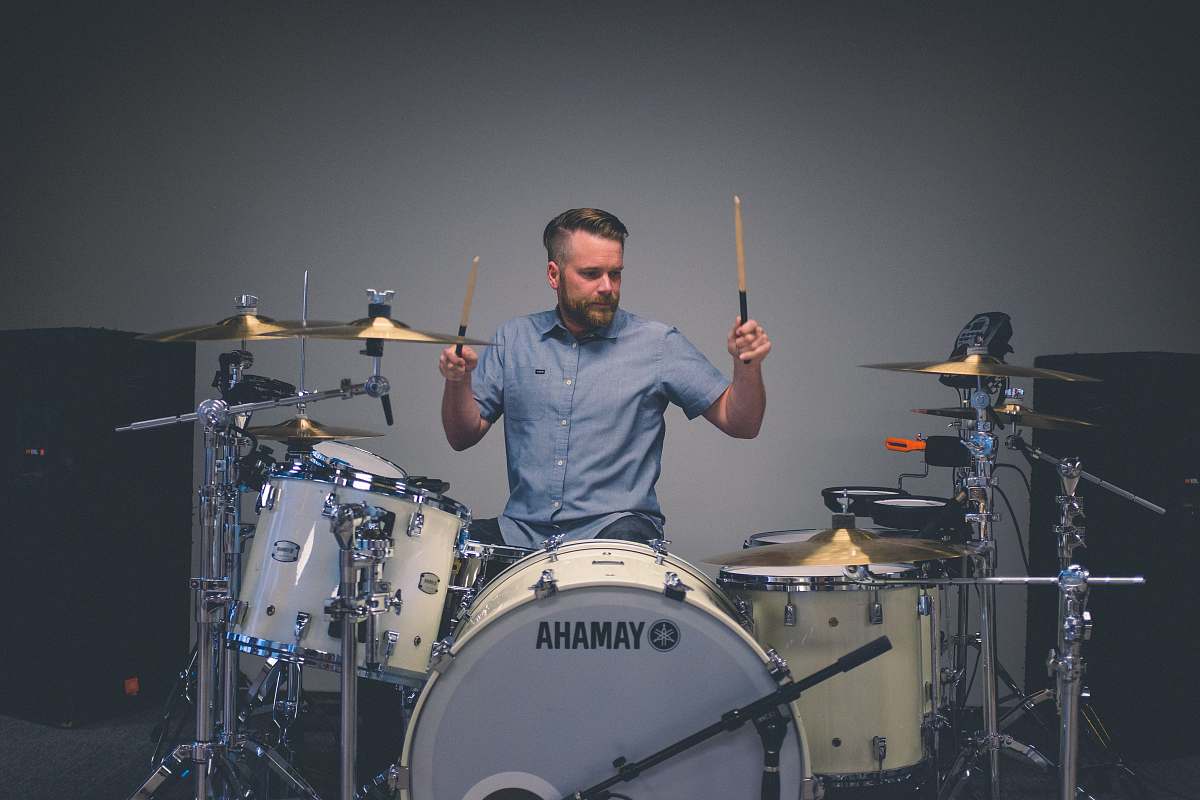 person man holding drum sticks with sitting on throne drummer