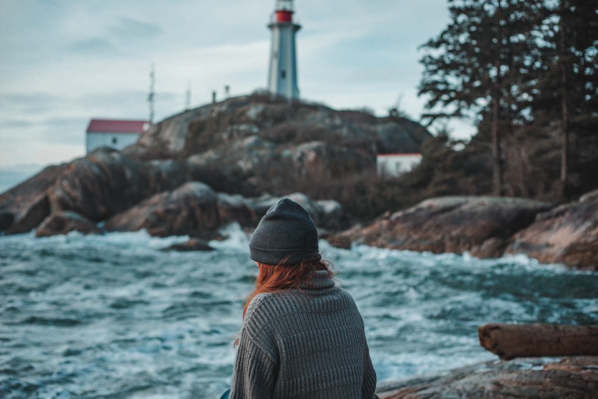 apparel man in black and white striped shirt standing near body of water during daytime clothing