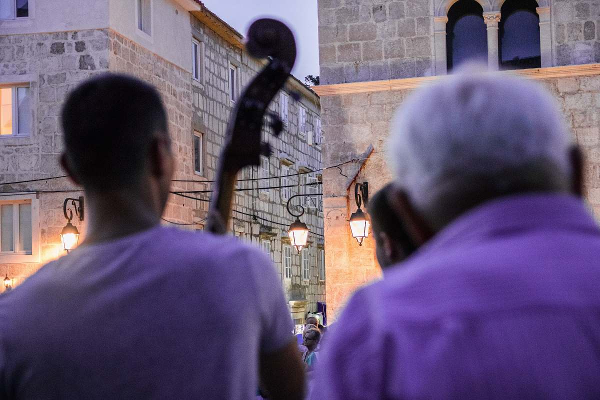 person man in purple shirt holding black dslr camera croatia