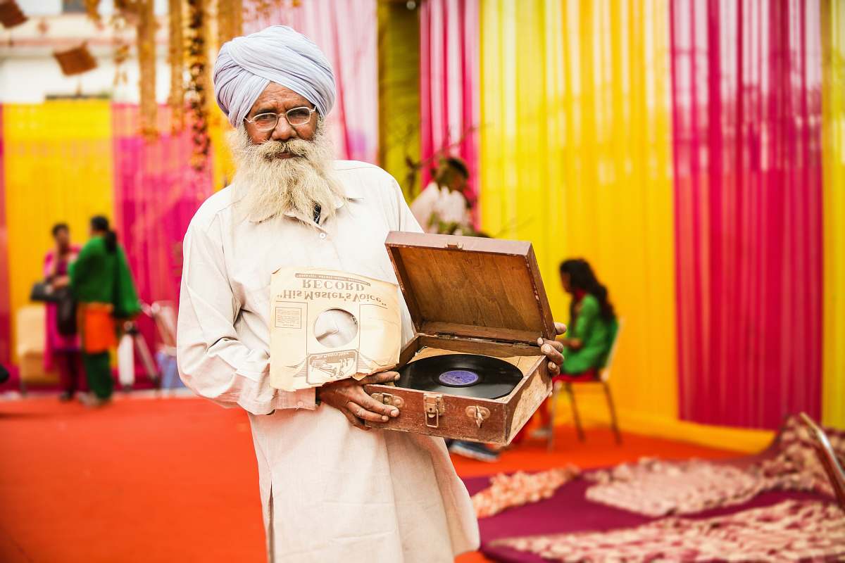 person man in white thobe holding vinyl player people