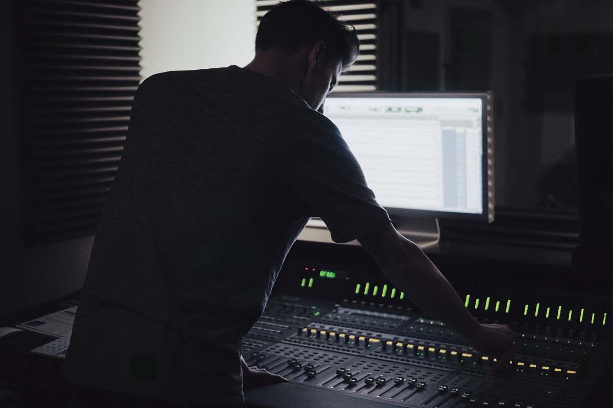 person man operating audio mixer studio