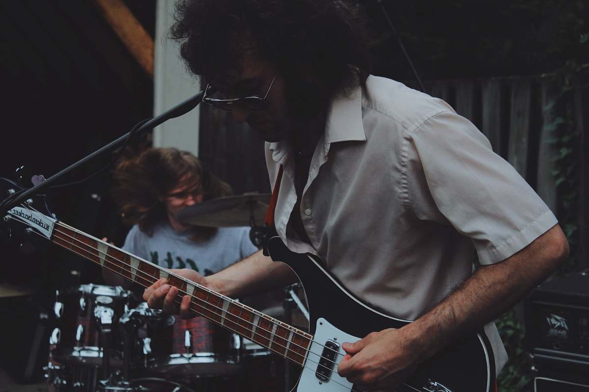 people man playhing guitar beside man playing drums person