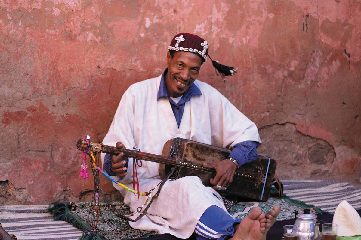 person man playing brown guitar guitar