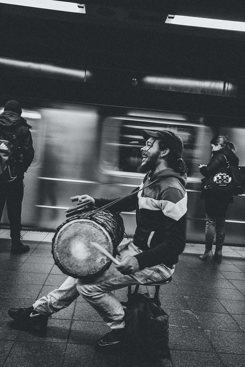 black-and-white man playing drum in subway grey
