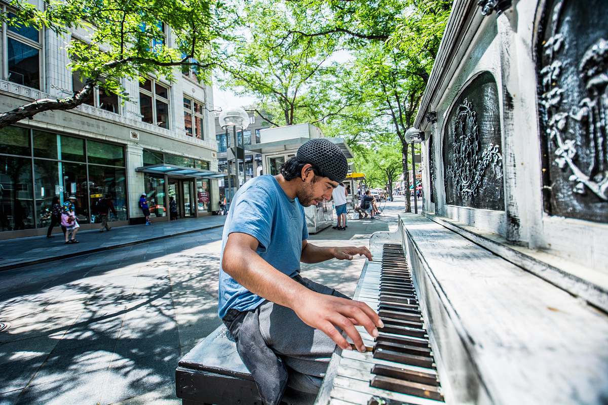 person man playing piano on street people