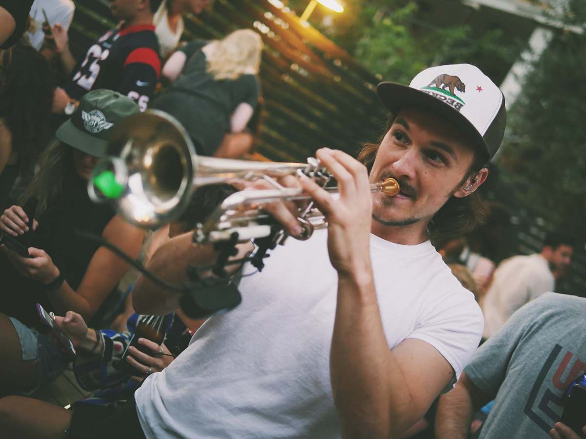 person man playing trumpet people