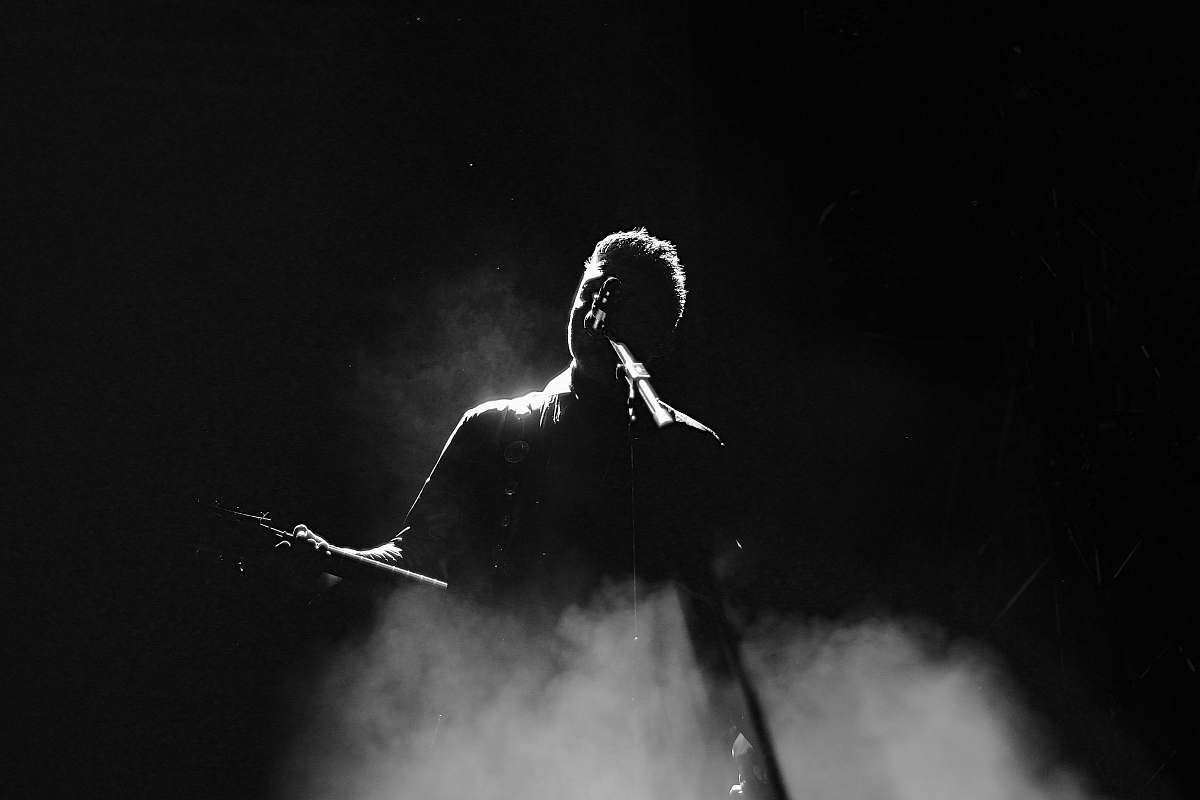person man singing on stage in grayscale photography black-and-white