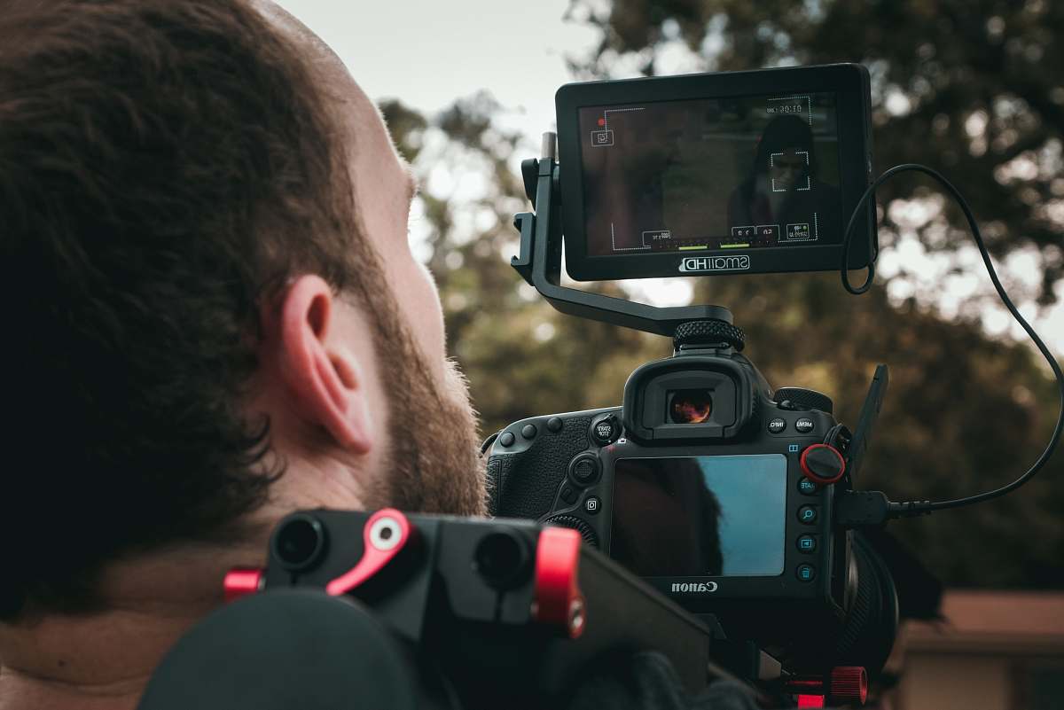 person man taking photo using DSLR camera camera