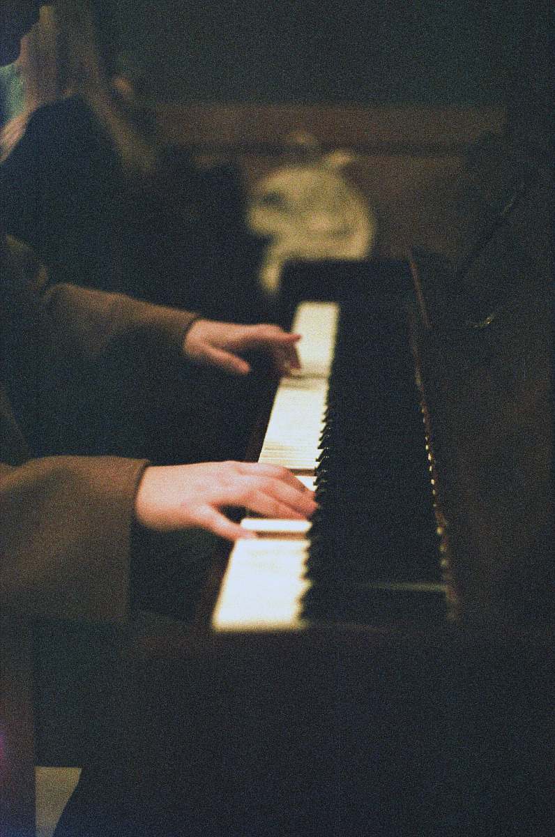 person person about to play white and black piano performer