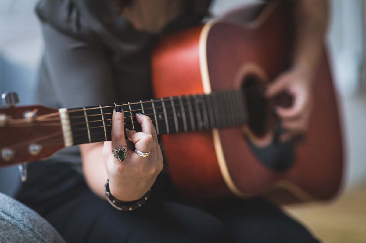 music person sitting while using guitar guitar