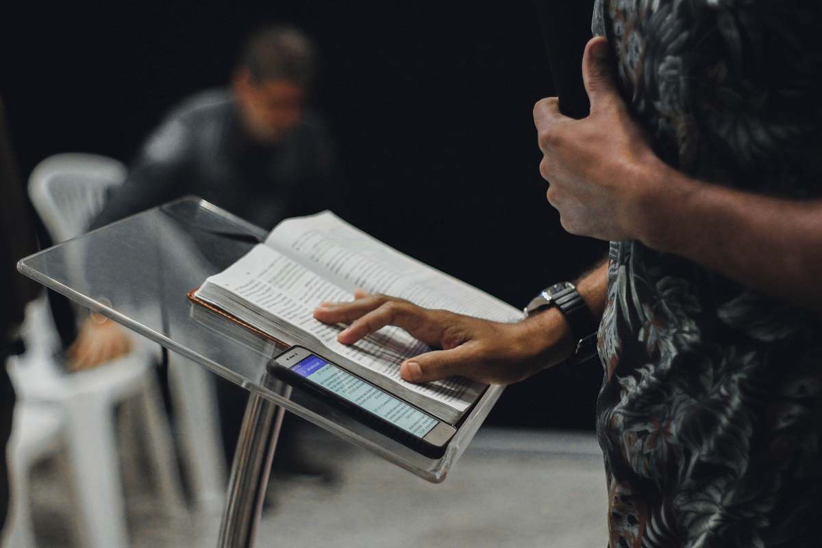 person person standing while opening book on stage people