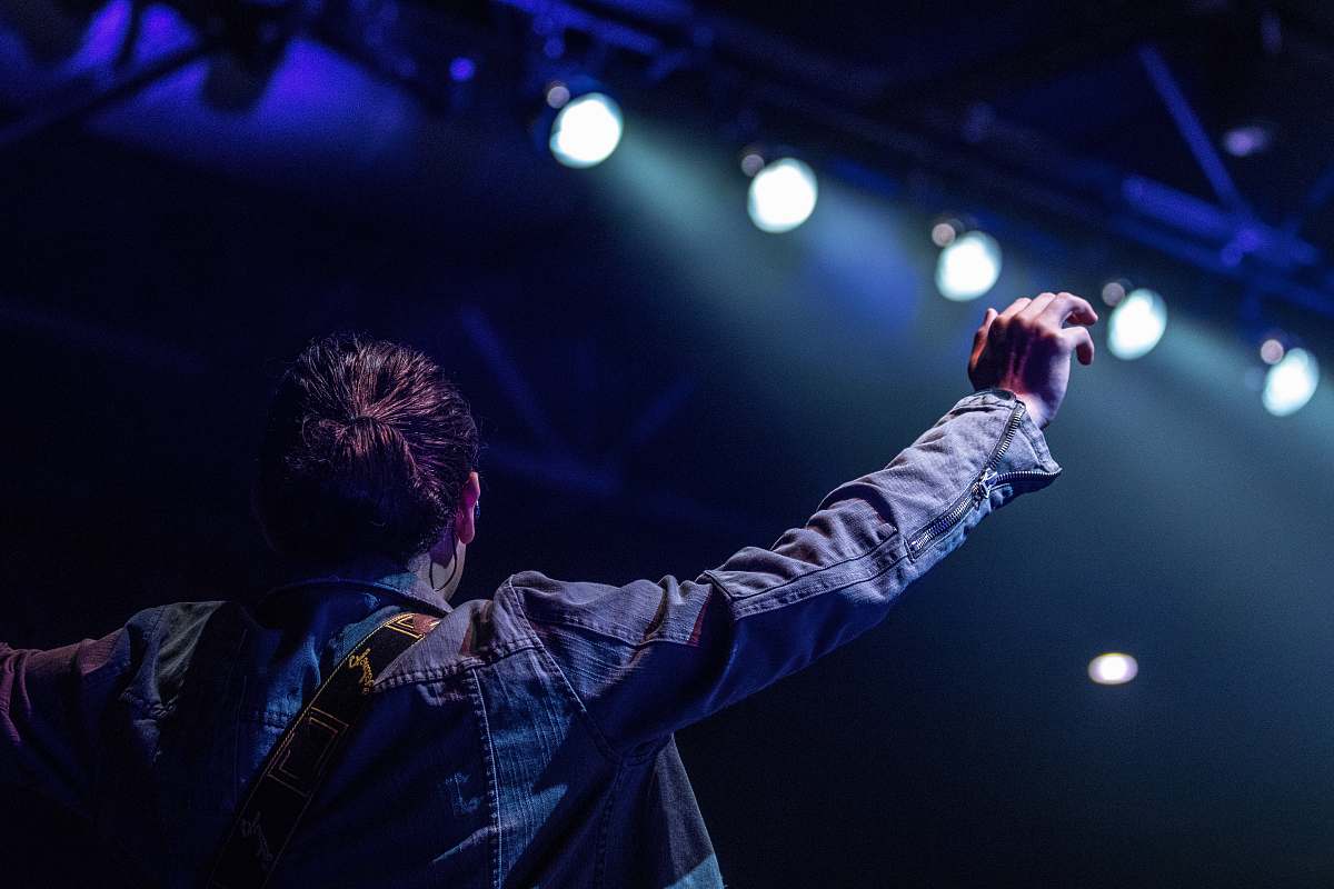 person selective focus photography of person on stage with lights people