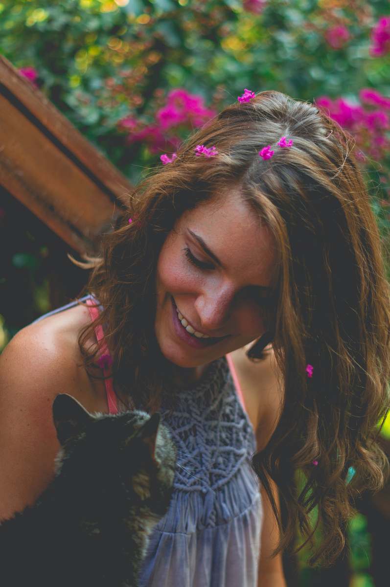 people smiling woman looking at brown tabby cat person