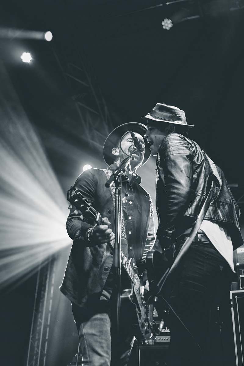 person two men singing on stage people
