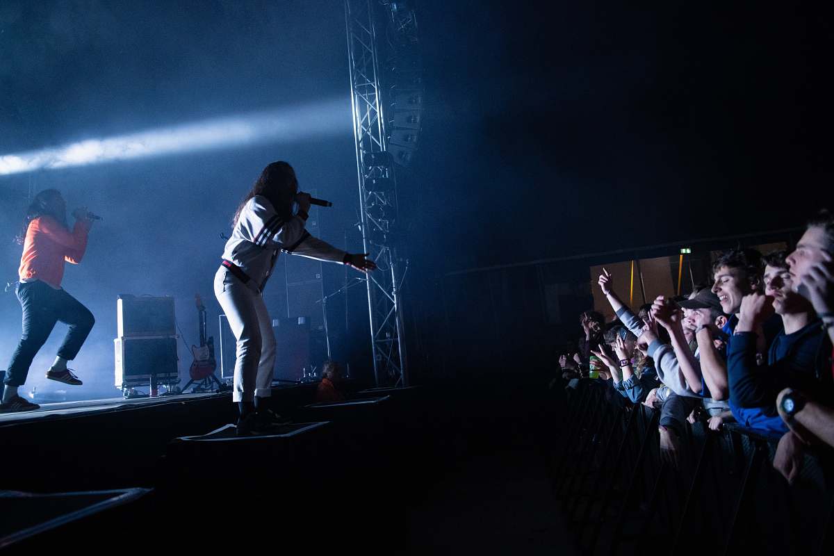 person two people performing on stage near people crowd