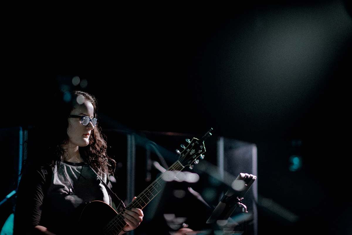 people woman playing guitar on stage person
