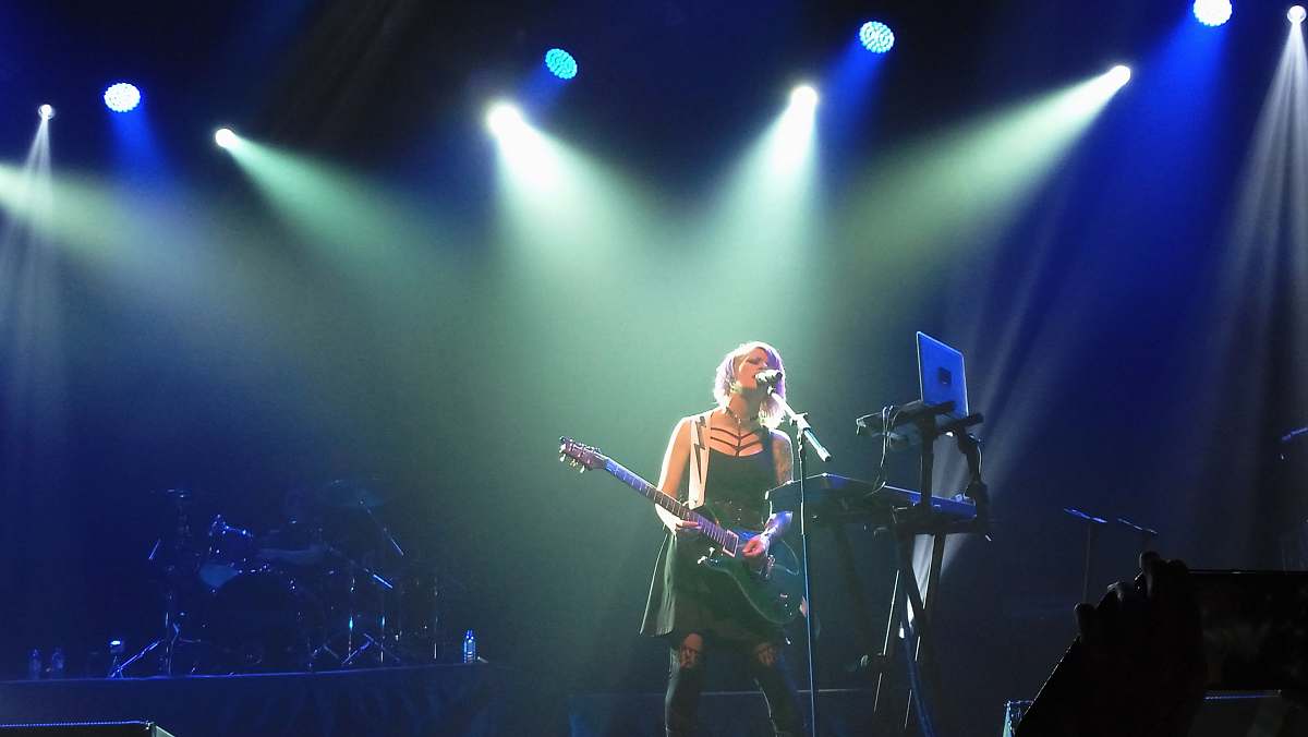 person woman playing guitar on stage people